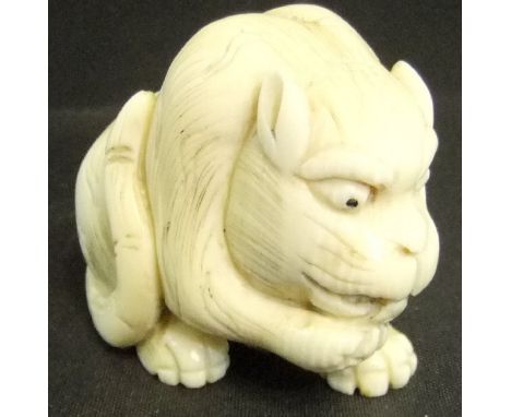 A Japanese carved ivory netsuke as a tiger licking it's paw, 3.5 cm high CONDITION REPORTS Very fine crack running from top o