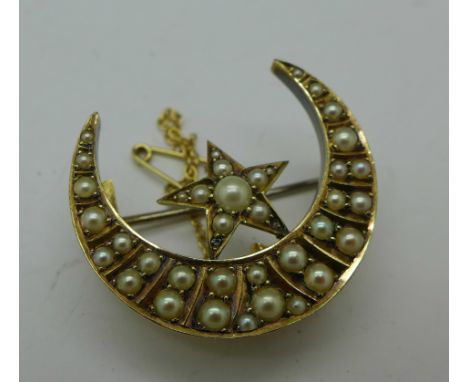 A yellow metal and seed pearl set half moon brooch