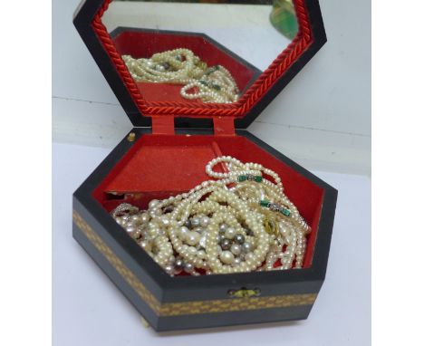 A marquetry jewellery box with pearl necklaces and bracelets