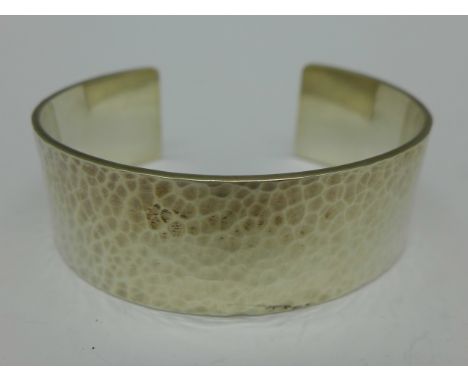 A hammered silver bangle, marked Pickle, 40g