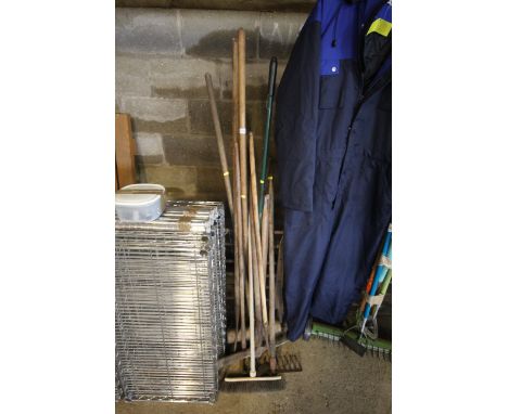 A quantity of long handled gardening tools to include rakes, brushes etc.