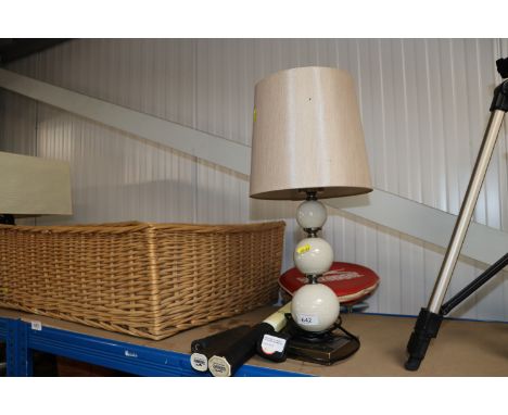 A vintage tennis racket; two badminton rackets and a table lamp