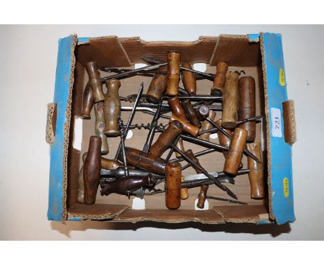 A box of wooden handled tools including augers and corkscrew