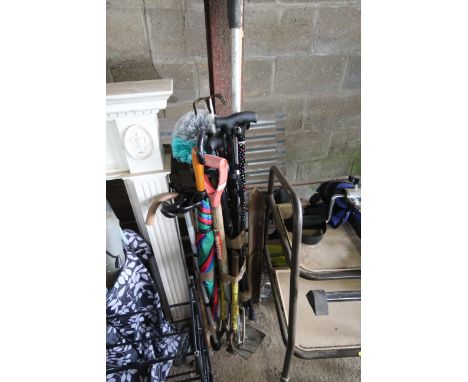 A quantity of walking sticks, umbrellas and garden tools