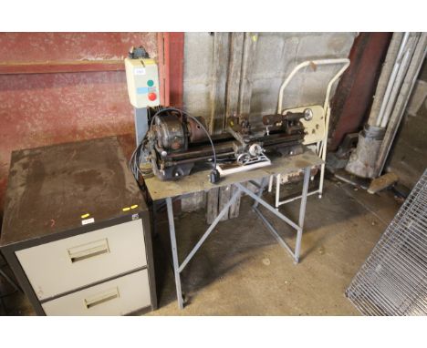 An Atlas lathe on metal base with lathe tools