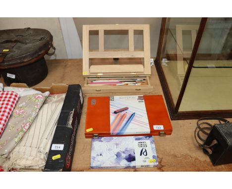 A box of acrylic paint; a sketching art box and an art box and easel 