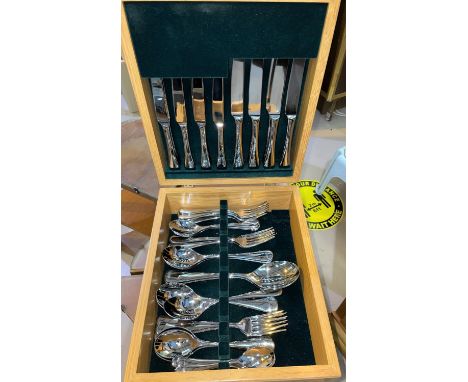 A modern light oak part canteen containing Welch designed stainless steel cutlery 