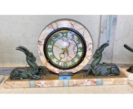 An Art Deco style marble mantle clock with circular central clock with two spelter antelope to either side on marble plinth 