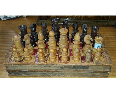 An antique turned and carved dark and light wood chess set with similar chess board (some chipping to a number of pieces-see 