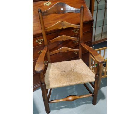 An Edwardian stained beech cane seat / commode armchair; a 19th century rush seat ladderback oak armchair and a circular 18th