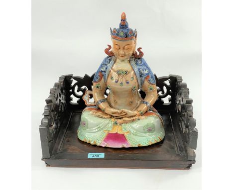 A Chinese ceramic Buddah with polychrome decoration, seated in lotus postition height 30cm, with assosiated hardwood carved s