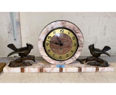 An Art Deco style marble mantle clock with circular central lock with two spelter birds on branches to each side on marble ca