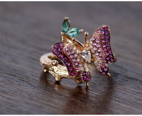 An 18k rose gold Emerald, Ruby and Diamond butterfly ring. Centrally set with single pear cut diamond, with single cut diamon