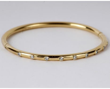 An 18k gold diamond set bangle. 15g. 