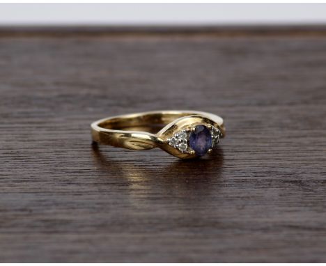 A 15k gold diamond and tanzanite dress ring. Centrally set with oval free cut tanzanite with diamond set shoulders. Size P  3