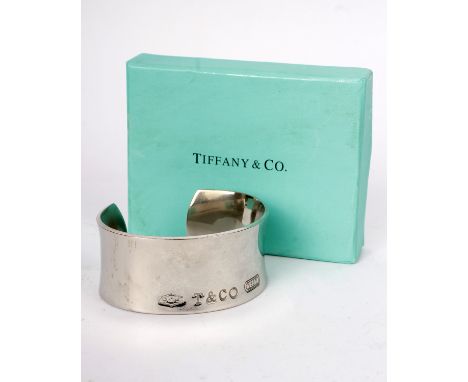 A sterling silver bangle by Tiffany &amp; Co, Stamped 925 Tiffany &amp; Co 1837. 70.1g. With original box and bag. 