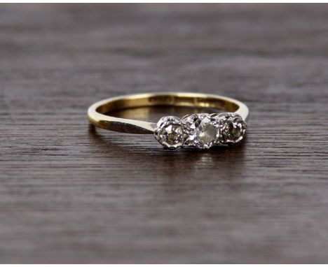 An 18ct gold and platinum three stone diamond ring. 3.0g Size P