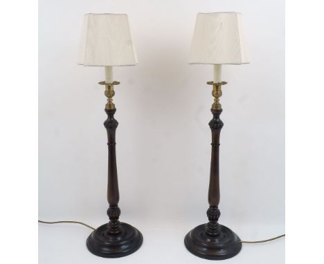 A pair of modern turned wood candlestick lamps, each with brass urn nozzle, shaped shades, 54cm high excluding fittings and s