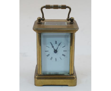 A Swiss miniature brass carriage timepiece, early 20th century, with bevelled glass panels and white enamel dial with Roman n