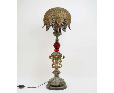 A large table lamp, 20th century, three bulb with domed filigree white metal shade and red cut glass decoration to stem, on s