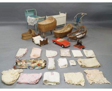 A Lloyd Loom style doll’s cradle, 65cm wide; together with a doll’s white painted wooden rocking cradle, 62.5cm wide; three w