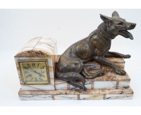 A French Art Deco eight-day spelter and marble mantel clock, 1930s, surmounted with a cast recumbent Alsatian signed L. Carvi