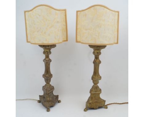 A pair of brass candlestick table lamps, 20th century, of columnar form with tripod legs and claw feet, converted for electri