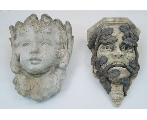 A composition stone garden wall bracket, late 20th century, modelled as a Green Man, mounted with trailing lead oak branches 