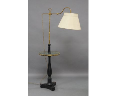 A floor standing brass and wood reading lamp, 20th century, with adjustable stem and arm and circular table with brass galler