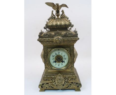 A French gilt-brass mantel clock, late 19th century, the architectural case surmounted with an eagle and decorated with masks