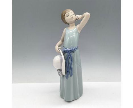 Glossy figure in long green dress with blue sash holding her hat in one hand and a shell to her ear with the other. Lladro ba