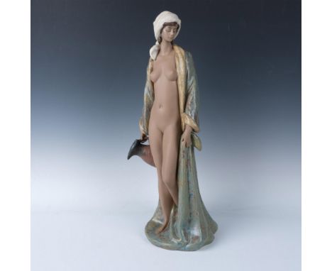 Hand painted figure of a beauty in a long multicolored robe. She is shown holding a large water pitcher. Lladro backstamp. Th