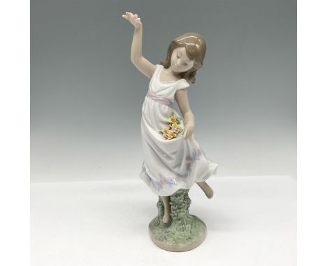 Glossy figure holding picked flowers in her dress while dancing in a meadow. 1999 Lladro Event figurine. Lladro backstamp. Th
