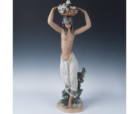 A stunning painted figure of an odalisca topless with a light-colored skirt and long dark hair. She is shown carrying a baske