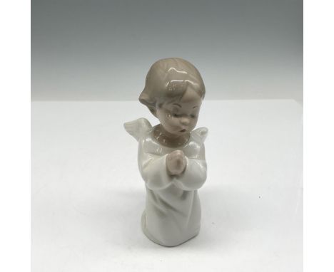 A figurine of a young angel child in serene prayer, adorned in a pristine white robe with graceful, open wings. Lladro backst