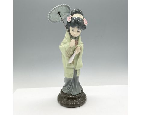 Glossy young Japanese figural dressed in green kimono with blue dress holding her umbrella and fan. Lladro backstamp. Artist: