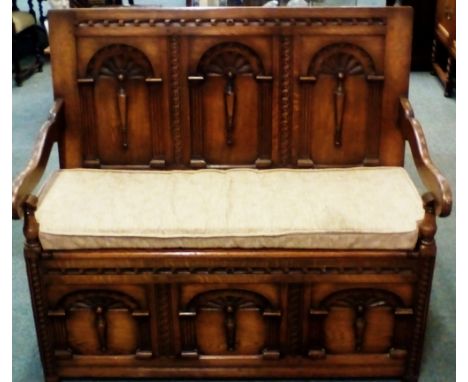 Solid oak monks bench, fielded panel back with palmettes and reeding, height 107cm, width 116cm