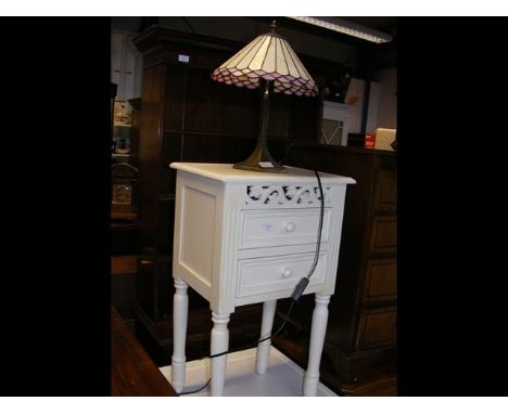 A cream painted bedside chest occasional table together with a Tiffany style table lamp