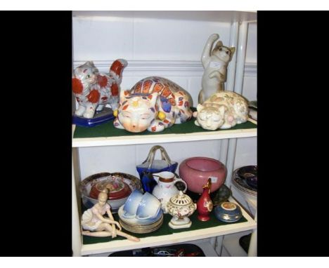 Two shelves of collectable ceramic ware including cats, ballerina