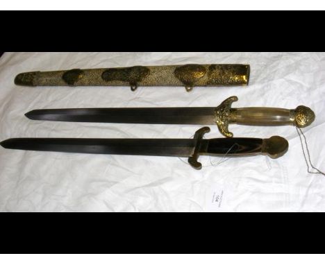 An unusual Oriental short sword, comprising of two separate swords in one and having decorative scabbard with metal embellish