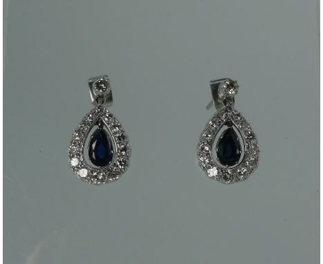 A pair of Pendant Earrings, formed of an open drop all diamond set, with a central suspended sapphire drop, the pillar with d