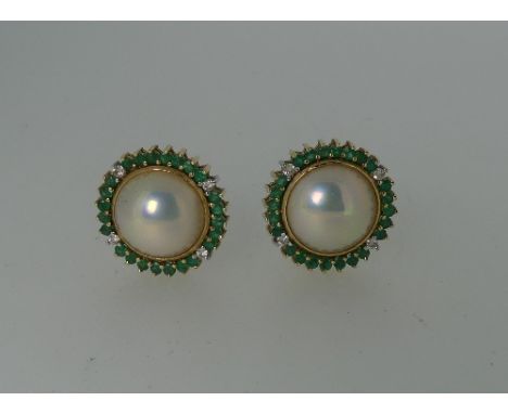 A pair of 14k yellow gold circular Earrings, the centres set with a half cultured pearl within a border of emeralds and four 