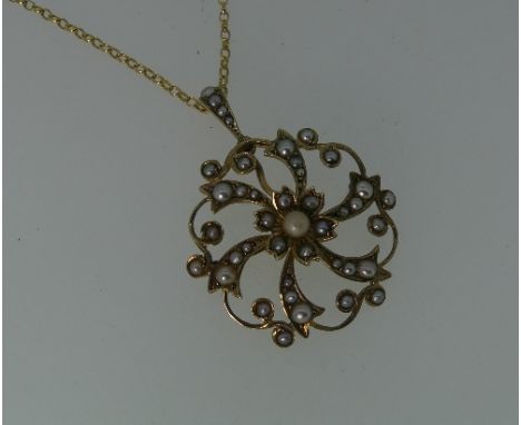 An Edwardian gold and seed pearl Pendant, of circular openwork scroll form all set seed pearls, on a 9ct yellow gold trace ch