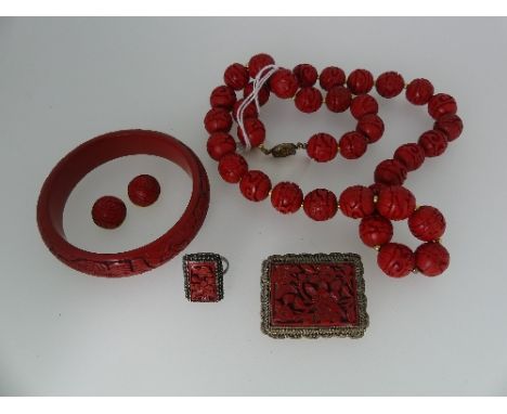 An early 20thC Oriental cinnabar carved circular bead Necklace, formed thirty seven beads with gilt balls between, with a sil