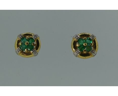 A pair of circular 18ct yellow gold Earrings, the centre set with four small emeralds, and with four white gold bars, each se