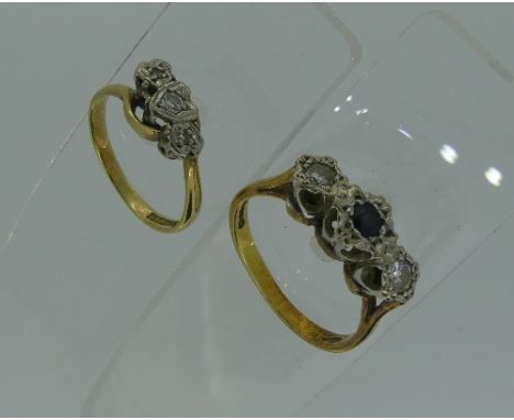 A three stone sapphire and diamond Ring, central sapphire with a small diamond on each shoulder, marked 750, Size M, together