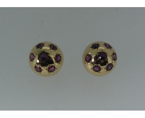 A pair of ruby set dome Earrings, each with seven ruby's gypsy set in unmarked yellow metal, pillar and clip fittings (2)