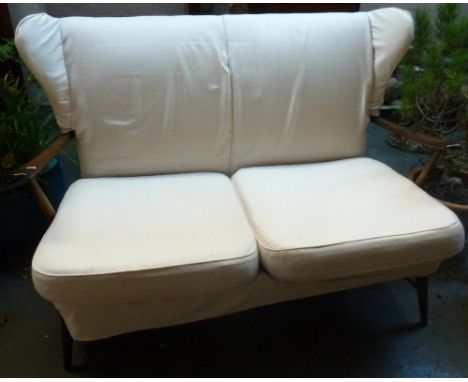 An early ercol wingback two seater sofa upholstered in cream