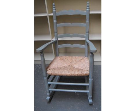 A painted vintage rocking chair with straw seat