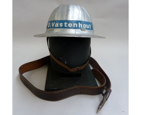 A vintage Dutch Groeneveld metal hard hat bearing name "D.Vastenhout" with leather chin strap and brown leather belt with bra